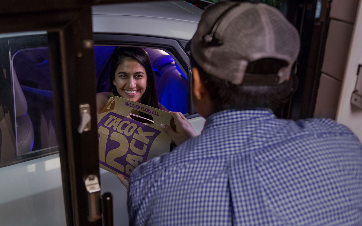 A Guest Picks Up A Bag Of Food At The Taco Bell Drive Thru