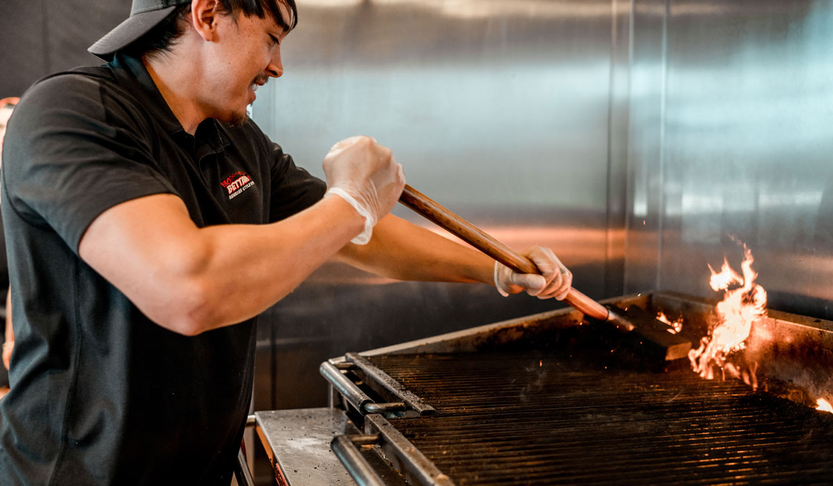 A Worker Operates The Grill At Mo’Bettahs Hawaiian Style