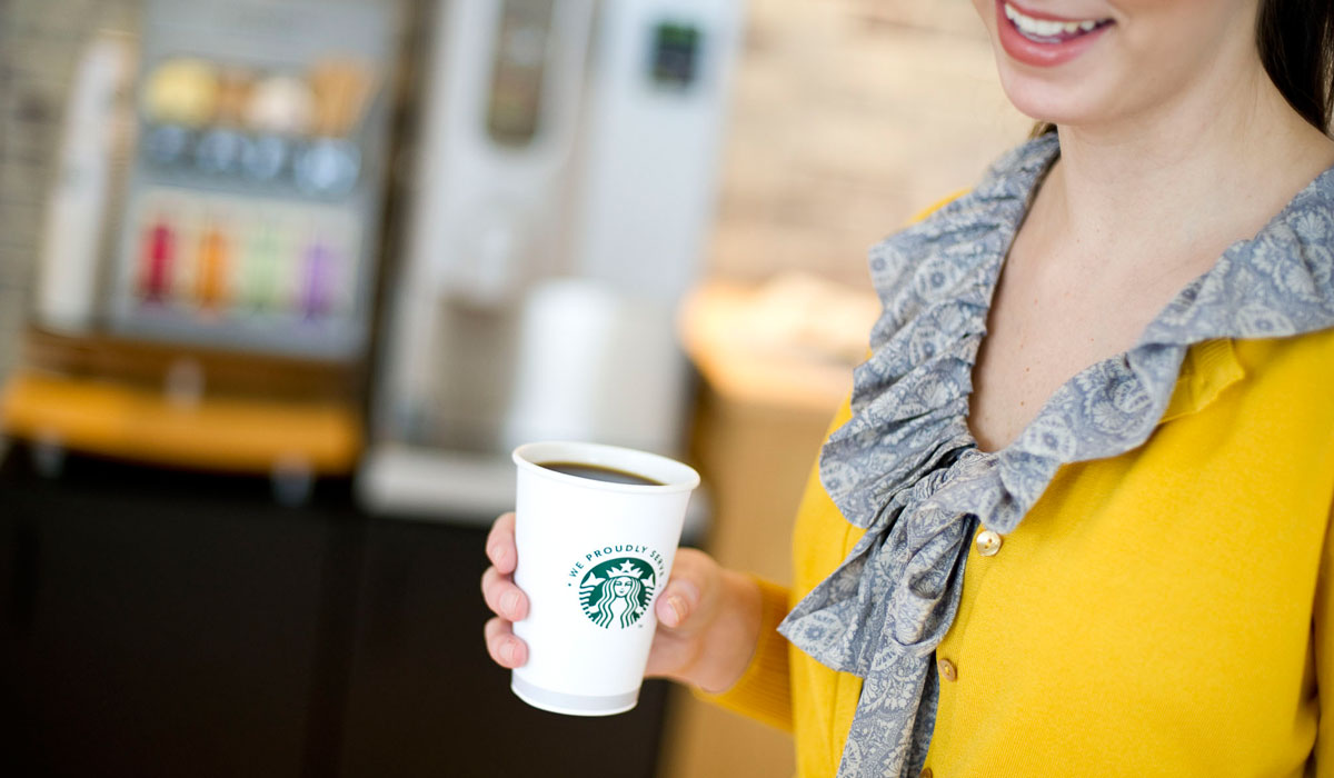 A Customer Holds A Starbucks Cup Of Coffee