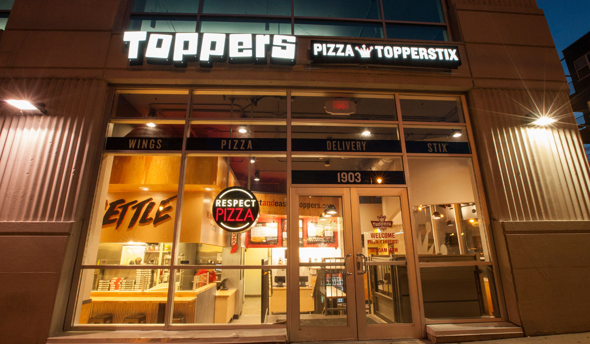 The Front Of A Toppers Pizza Restaurant At Night
