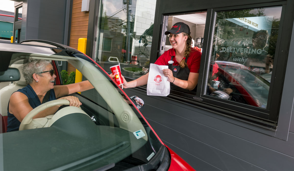 Wendy's Employee Serves A Customer Through The Drive Thru Lane
