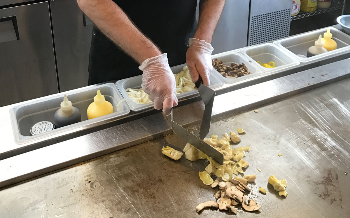 A Worker Cooks A Sandwich On The Flat Top At Penn Station Fast Casual