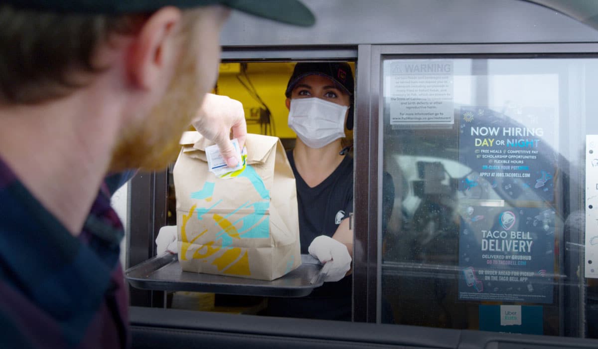 Taco Bell Drive Thru Employee Wearing A Mask Hands Food To Customer