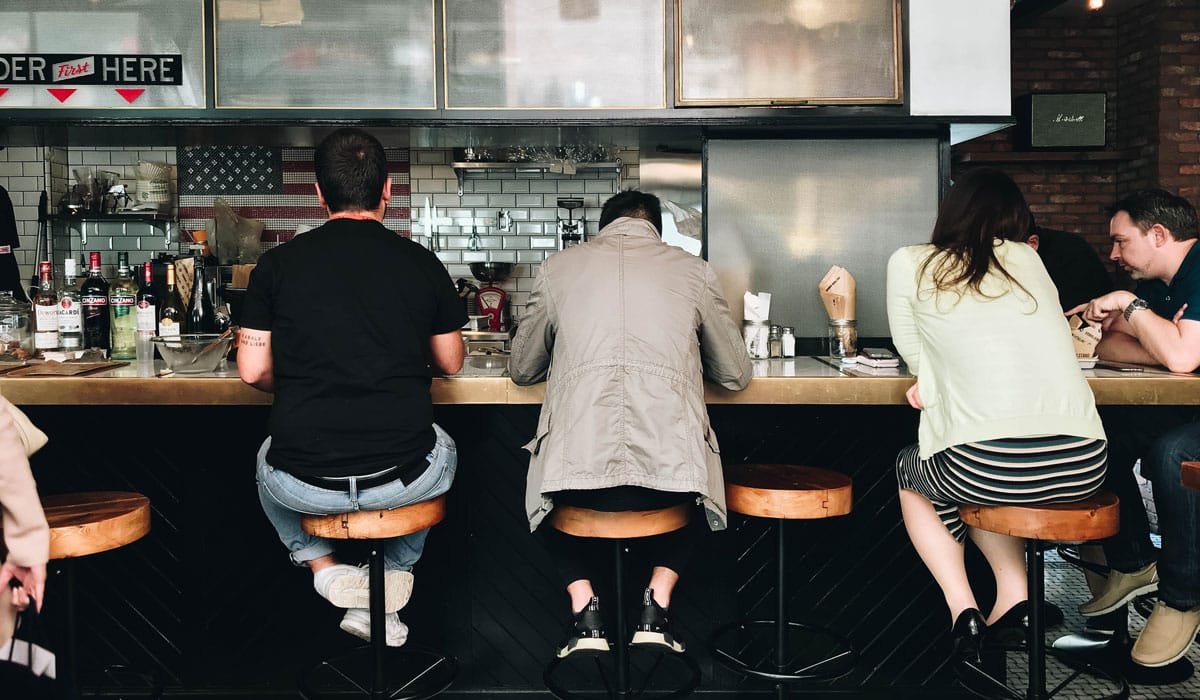 Restaurant Restaurant Goers Sit At Stools In Front Of A Counter