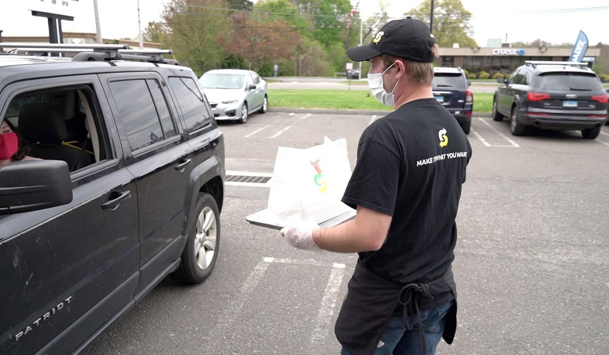 Subway Employee Bringing Curbside Order Over To Car