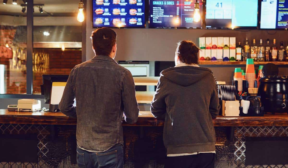 Two Men Choose Food In A Fast Food Restaurant