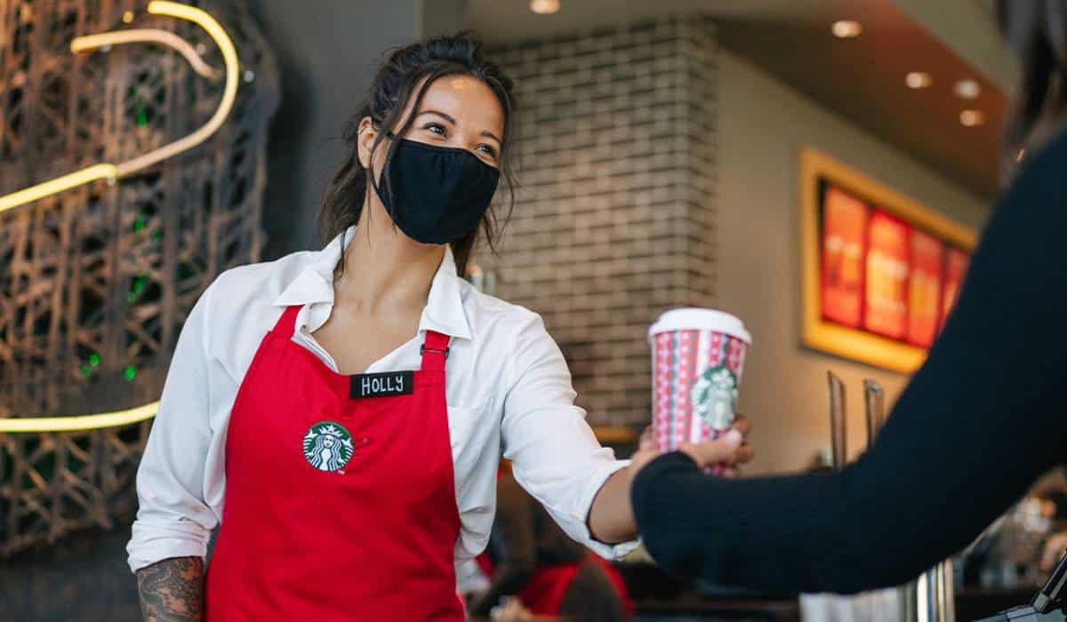 Starbucks Employee Giving A Drink To A Customer