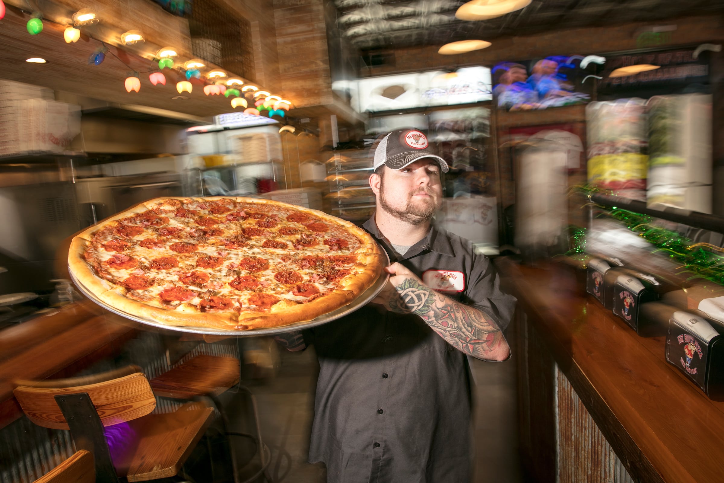 Fat Boy’s Pizza Employee Holding A Pizza