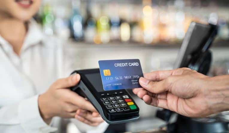 A customer handing a credit card to an employee.