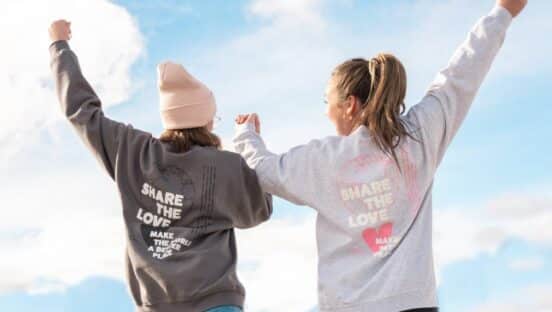 Two women wearing 'Share the Love' T-Shirts.