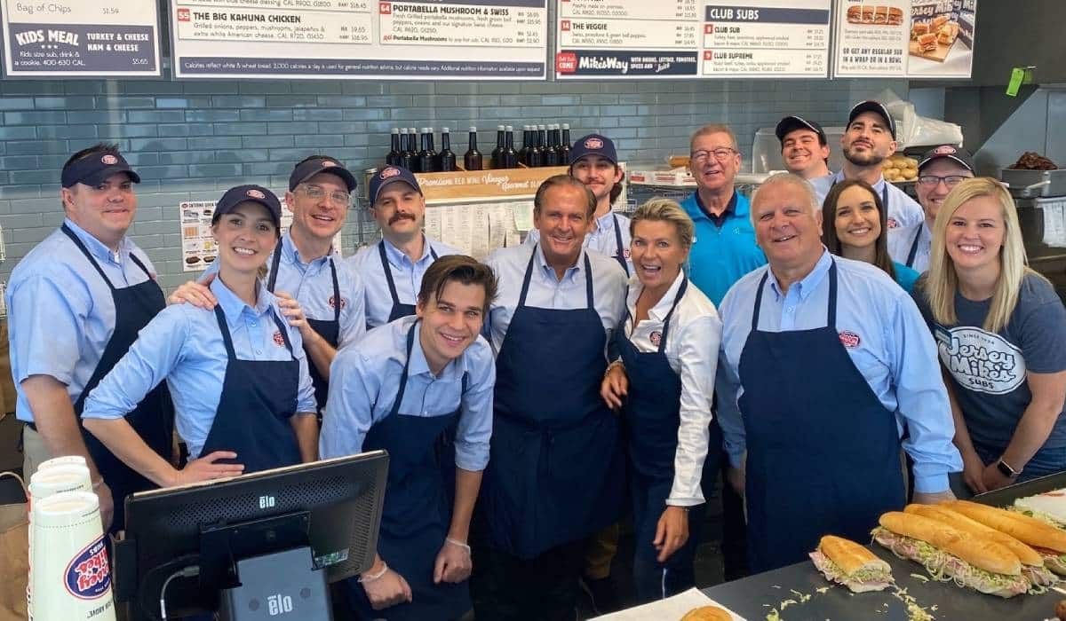 Jersey Mike's employees and CEO inside a restaurant.