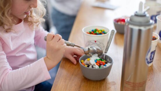 A child eating a bowl of Handel's ice cream.