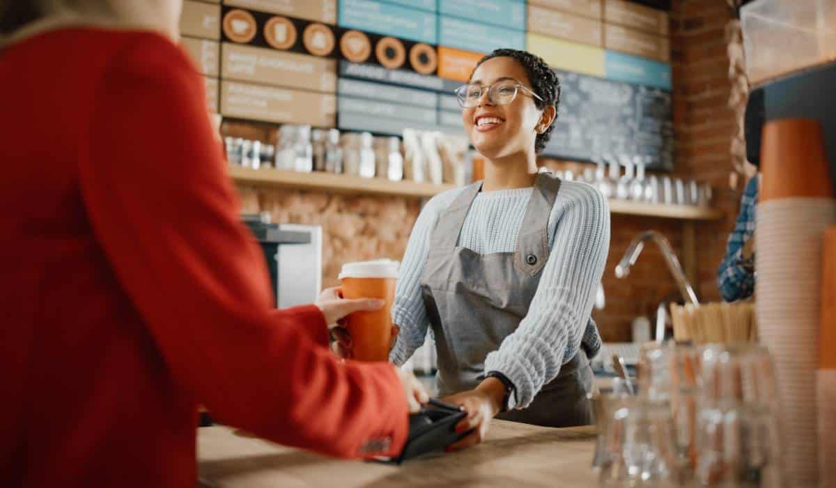 Barista hands payment option over to customer.
