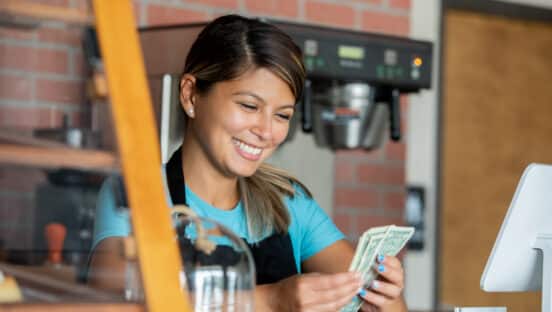 Barista counting her tips after working shift at local coffee shop.