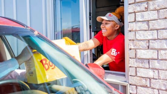 Bojangles drive-thru with employee handing box to customer.