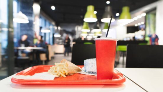Red tray with fast food menu is on the table in the restaurant.