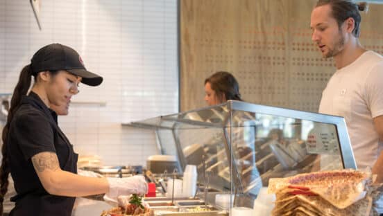 Chipotle employee serving a customer.