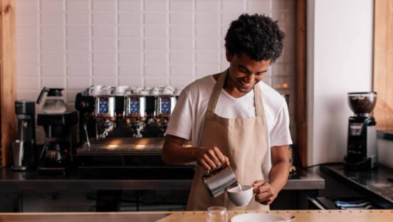 Professional barista preparing coffee on counter.