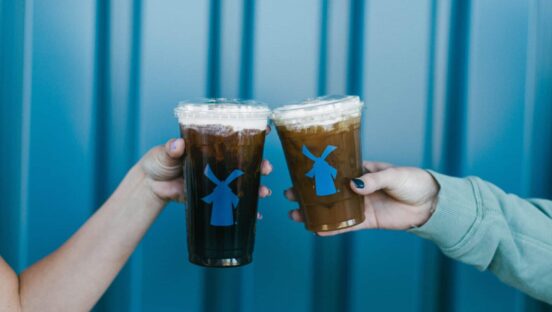Customers clinking Dutch Bros drinks.