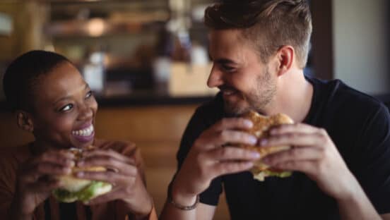 Couple eating burgers.