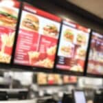 Restaurant menu boards blurred inside a fast-food restaurant.