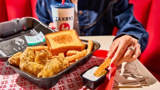 Zaxbys chicken fingers and sauce and customer dipping into sauce.