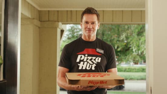 Tom Brady holding a Pizza Hut box.