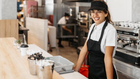 Restaurant employee smiling by the counter.