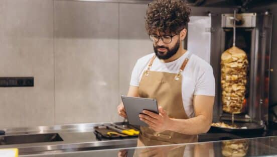 Fast food worker holding a tablet.