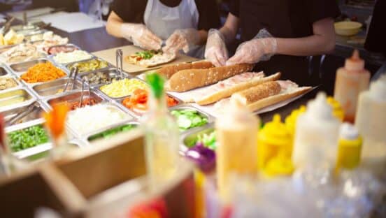 Fast food employees making sandwiches.