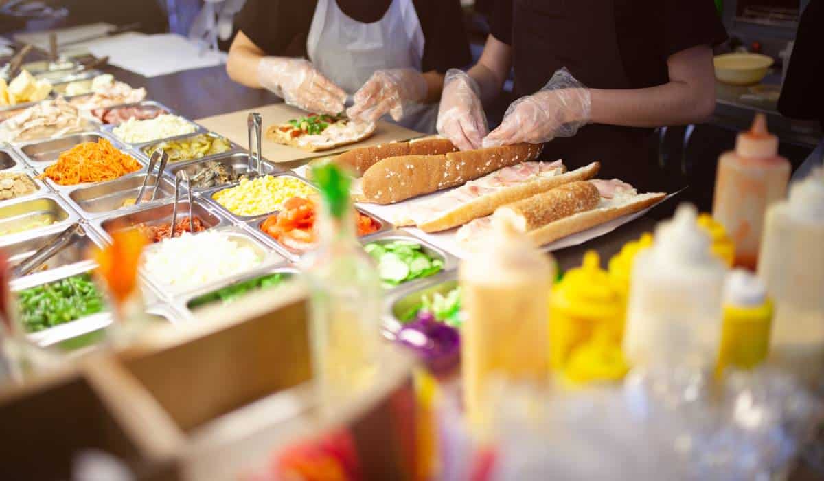 Fast food employees making sandwiches.