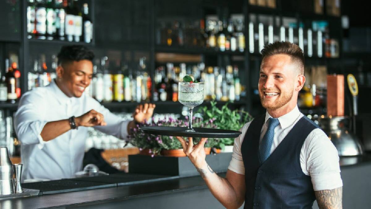 Waiter holding cocktail tray.
